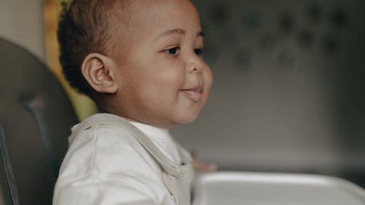 baby sitting in a high baby chair
