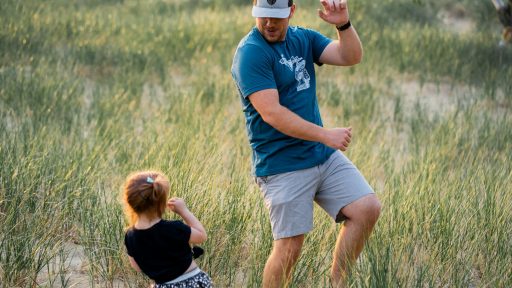 father and daughter playing in a meadow