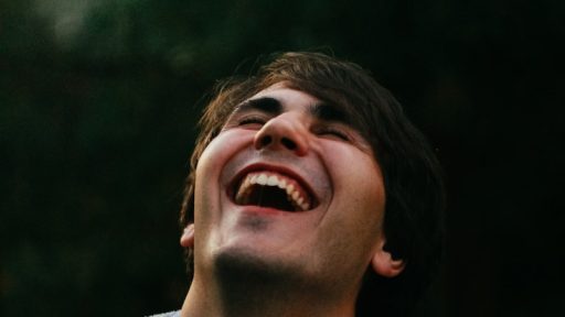 man in gray sweater smiling