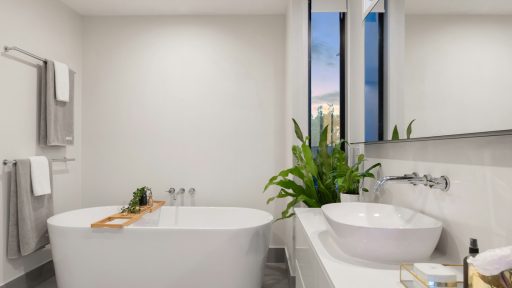 white ceramic bathtub near green potted plant