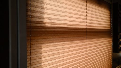 Sunlight streaming through blinds creating warm shadows in a room.