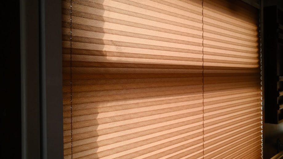 Sunlight streaming through blinds creating warm shadows in a room.