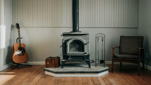 a room with a chair, a guitar and a stove