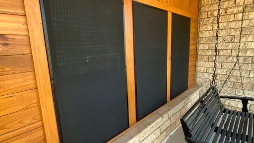A black bench sitting next to a brick wall