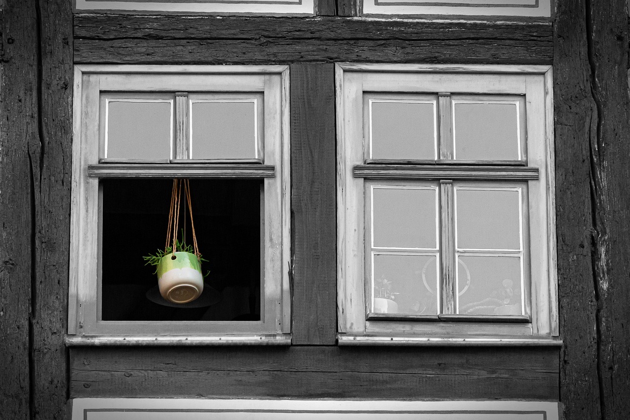 Sfeervol gestyled vensterbank met planten, keramiek en een vaas in aardetinten