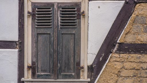 Interieur van een oude boerderij met zichtbare houten balkconstructie en authentieke plavuizen vloer