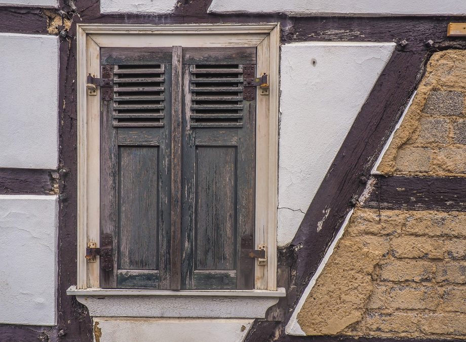 Interieur van een oude boerderij met zichtbare houten balkconstructie en authentieke plavuizen vloer