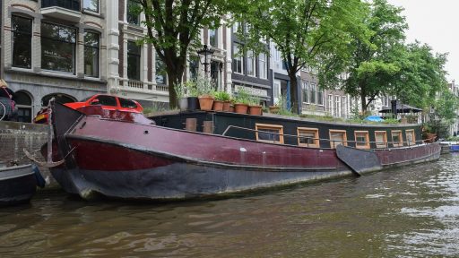 Historisch grachtenpand in Nederland dat wordt gerestaureerd, met steigers aan de gevel