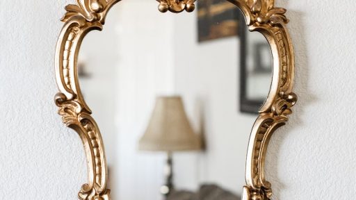 a mirror hanging on a wall next to a lamp