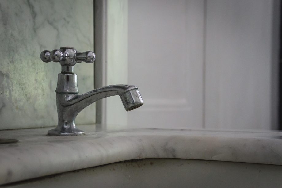 Authentieke jaren-30-badkamer met roomwitte metrotegels en klassiek sanitair op voetstuk