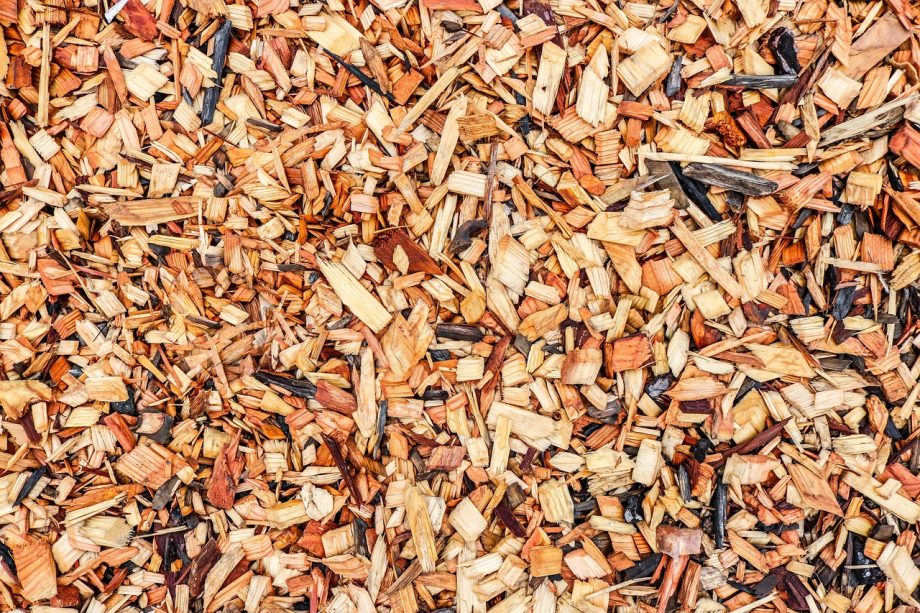 Laag houtsnippers als mulch rond planten in een sierborder