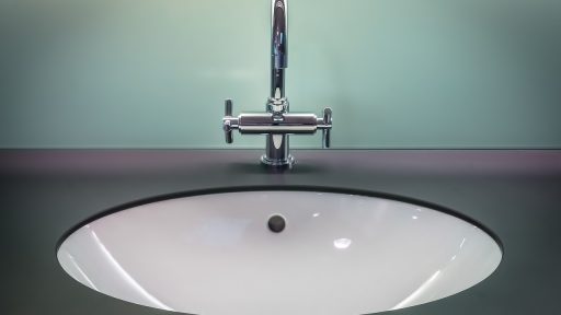 Badkamer met goudkleurige kraan en bijpassende metalen accessoires