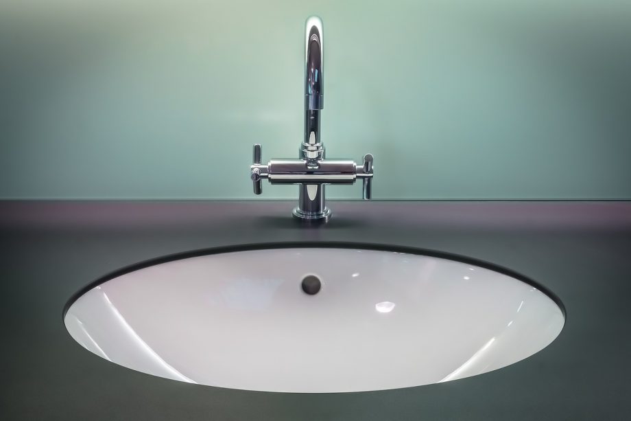 Badkamer met goudkleurige kraan en bijpassende metalen accessoires