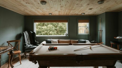 Pool table in a room with wood ceiling and sofa