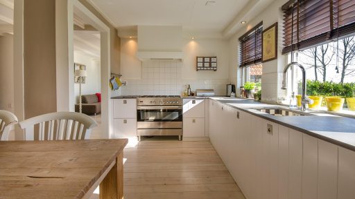 Een moderne glazen aanbouw aan een woning met veel lichtinval vanuit de tuin