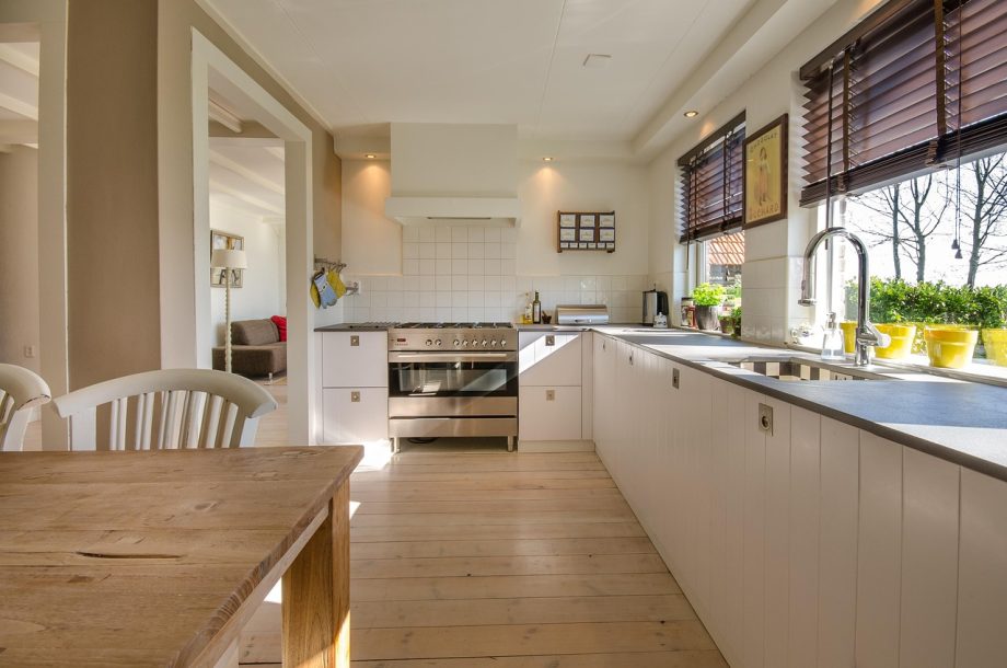 Een moderne glazen aanbouw aan een woning met veel lichtinval vanuit de tuin