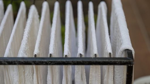 Badkamer met zichtbare condens op tegels en een ventilatieroosters aan het plafond